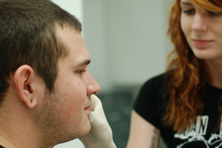 Our piercing apprentice Heather cleaning the area
